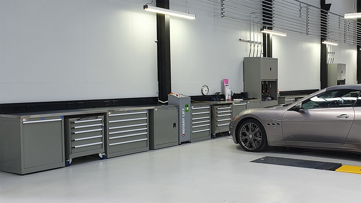 An automotive workshop displaying some of BAC Systems trolleys, workbenches and cabinets in front of a sports car.